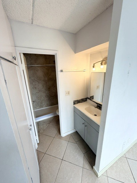 A bathroom with a sink, mirror, and a door.